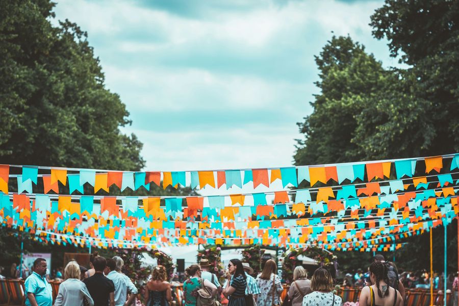 Rows of colourful bunting strung above visitors at a summer street event